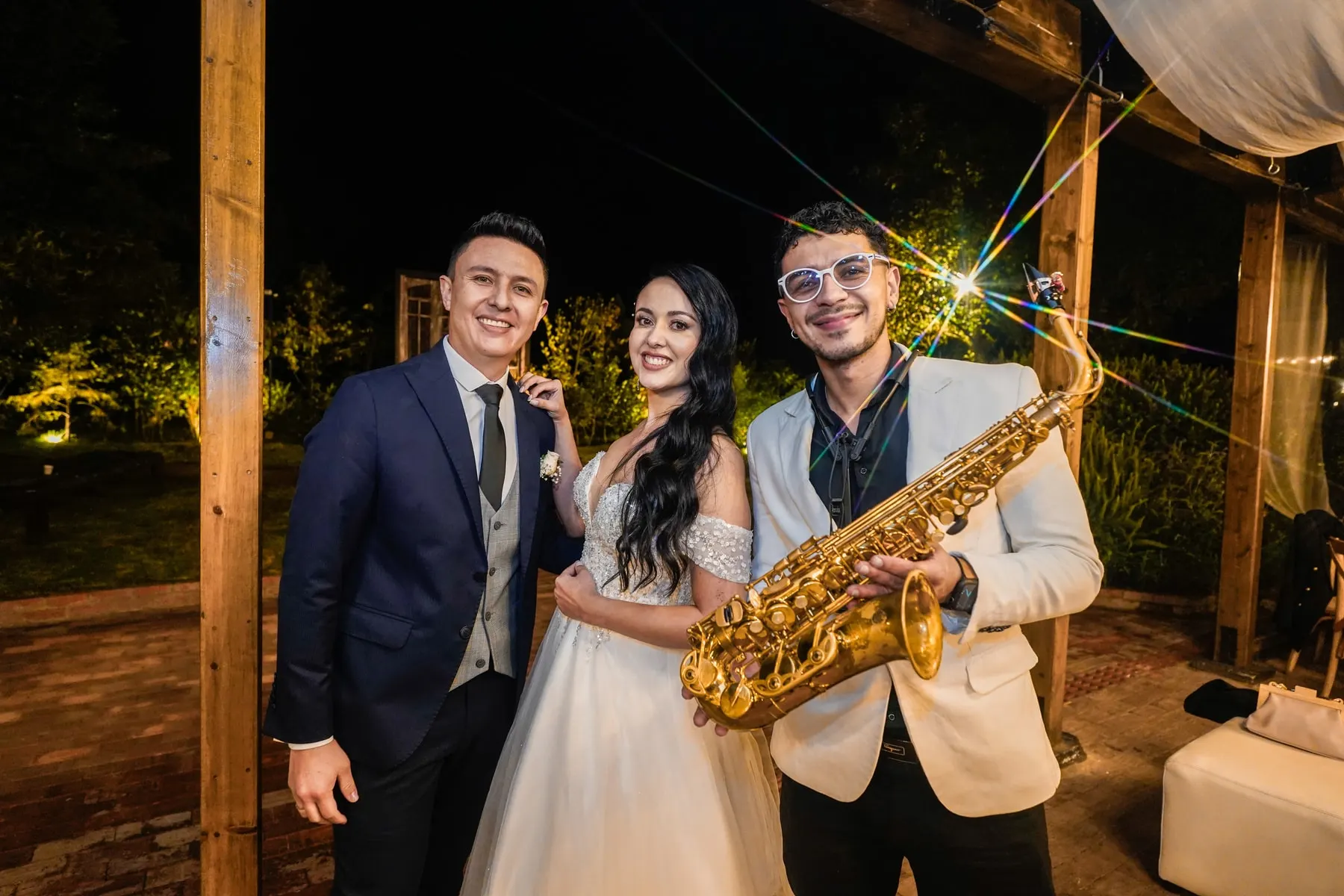 Pareja de novios con un saxofonista de Golden Artists en su boda en Bogotá