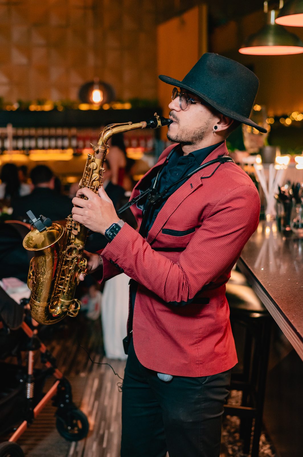 Saxofonista de Golden Artists en un show de boda con luces cálidas